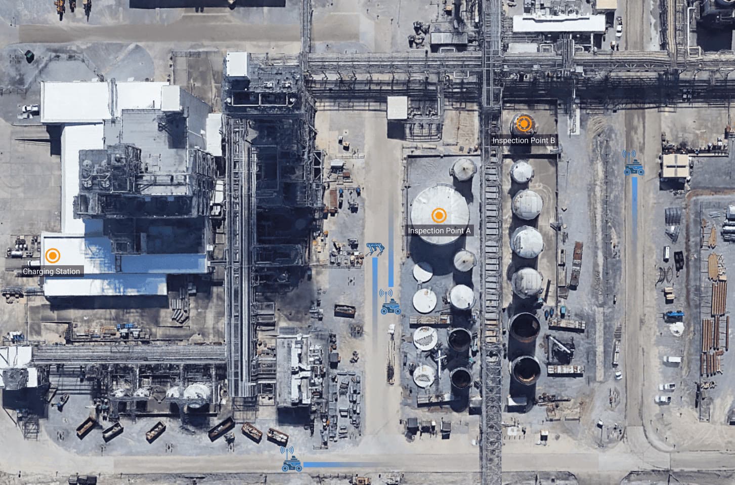 Aerial view of an industrial site with robots, their paths in blue, and labelled inspection points and a charging station.